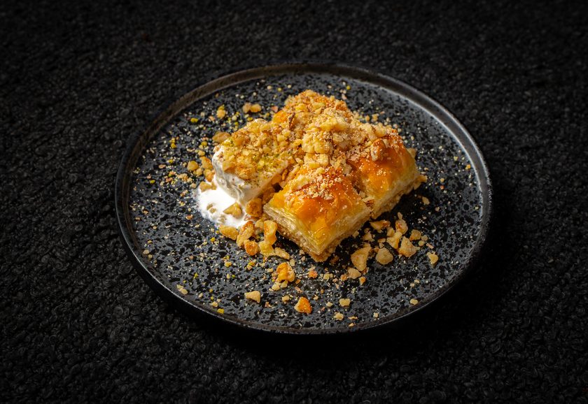 Baklava topped with crushed nuts, served with clotted cream