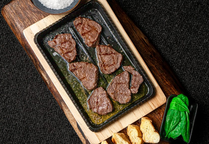 Медальоны из говядины на раскалённом камне с зелёным маслом, морской солью и тостами