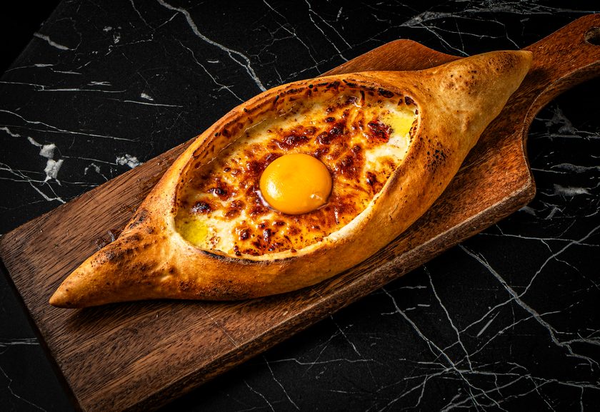Boat-shaped khachapuri with molten cheese and an egg yolk