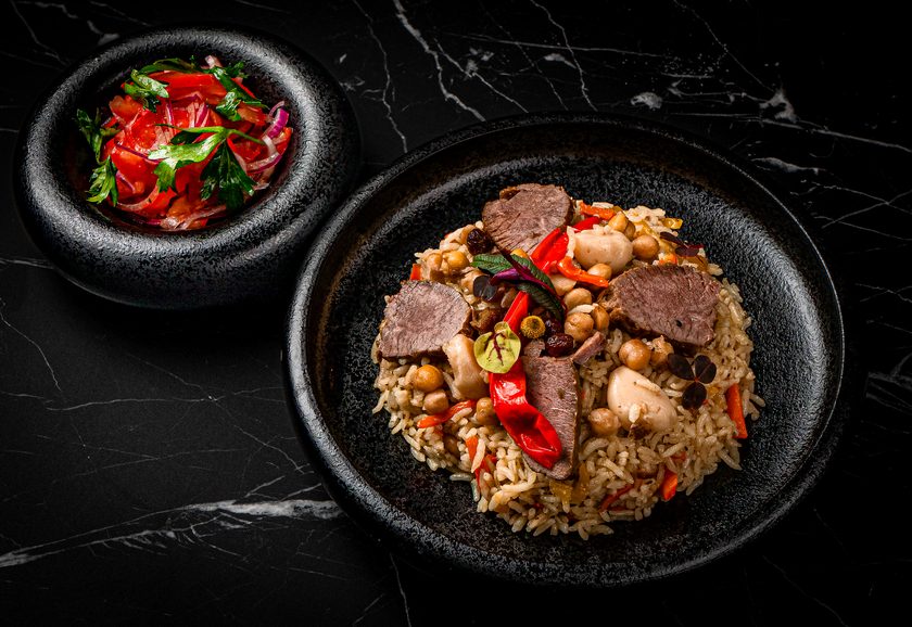 Uzbek plov with lamb, chickpeas and red pepper, with a tomato and onion salad alongside