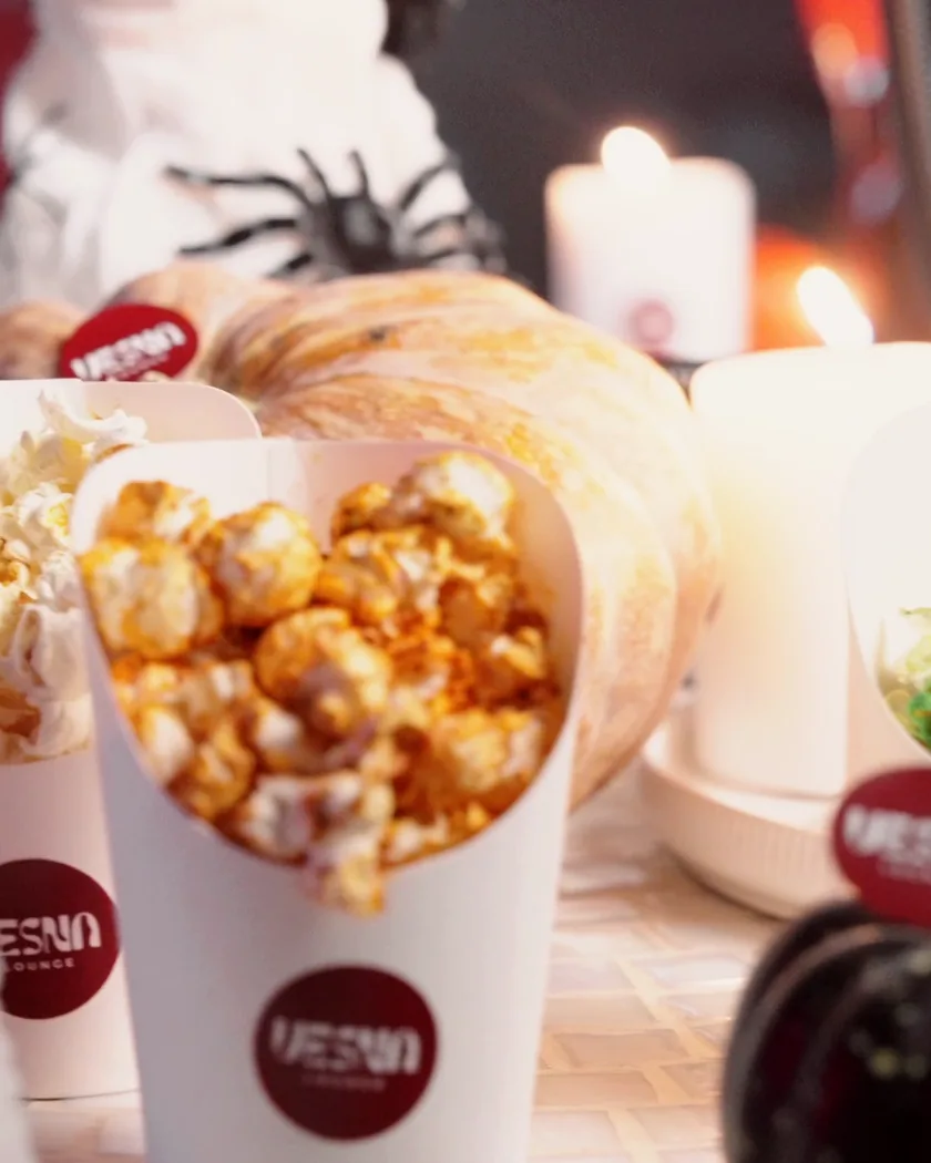 Popcorn in Vesna cups beside candles and pumpkins, ready for the movie
